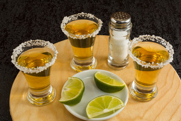 Gold tequila shots on the round wood board