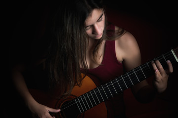 Beautiful teenage girl playing a guitar