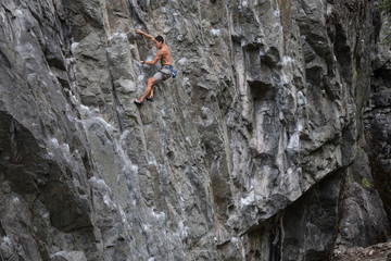 Rock Climber climbing a steep cliff on a mountain. Taken near Squamish, British Columbia, Canada