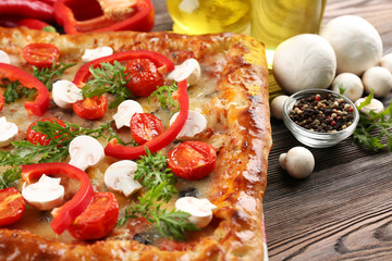 Freshly homemade pizza on wooden table closeup
