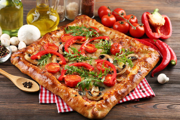 Freshly homemade pizza on wooden table closeup