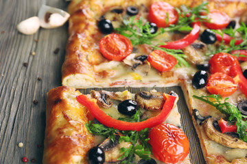 Freshly homemade pizza on wooden table closeup