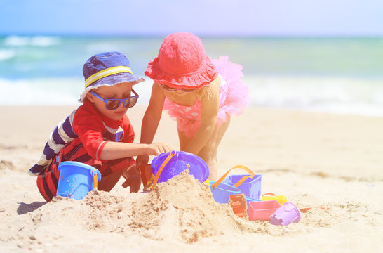 kids play with sand on summer beach