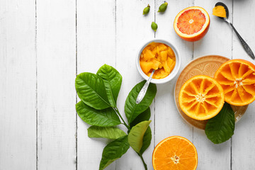 Eating oranges with spoon on white wooden table