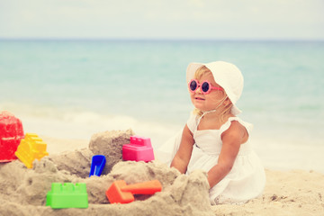 cute little girl play with sand on beach