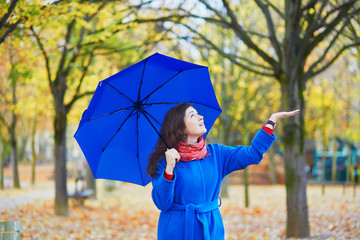 Beautiful young woman with blue umbrella