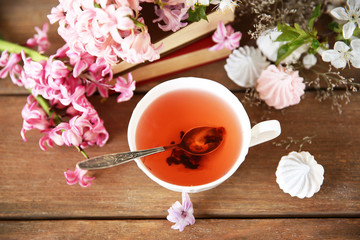 Cup of tea and flowers on wooden table