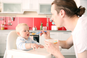 Fototapeta premium Father feeding his baby son