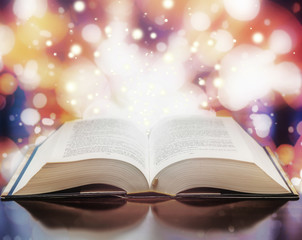 Open book with light particles