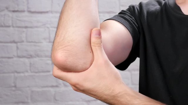 Man holding his elbow and feeling pain.