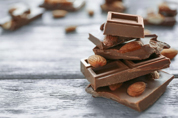 Chocolate pieces with nuts on wooden background
