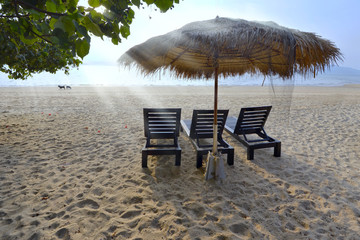 Vacation holidays background wallpaper - three beach lounge chairs under tent on beach ,Ranong , Thailand.