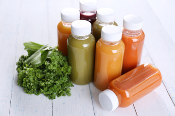 Diet concept: vegetable juices in bottles on wooden background