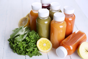 Diet concept: vegetable juices in bottles on wooden background