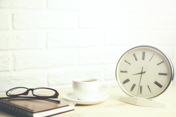 glasses  on notebook and coffee,clock on table