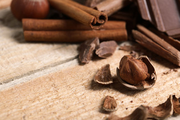 Chocolate pieces with cinnamon on wooden background