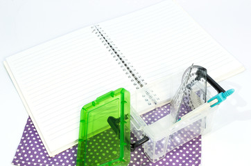 Obraz premium Empty white paper notebook with ruler, protractor, angle, triangle, square on the white background.