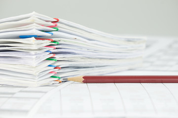 Brown pencil and overload of paperwork on white background
