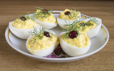 Stuffed egg with cranberry and green dill