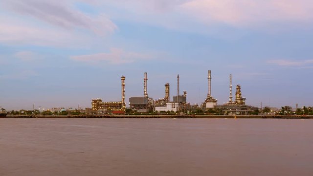 Oil Refinery or Oil Industry in front of Chao Phraya River, and sky sunset Day to night and ship transportation and factory concept High quality in 4K Timelapse