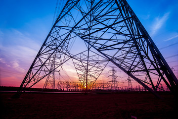 The silhouette of the evening electricity transmission pylon