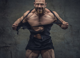 Fototapeta na wymiar Huge bodybuilder rend his garments.