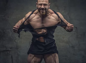 Foto op Plexiglas Huge bodybuilder rend his garments. © Fxquadro