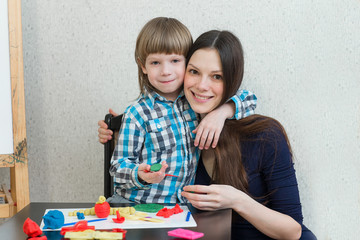 Naklejka premium child kid boy and mother play colorful clay