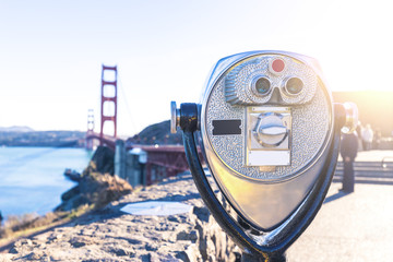 touristic telescope with gold gate bridge in sunny sky