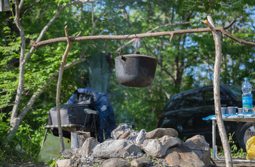 Camping pot on a background of trees. Over the fire.