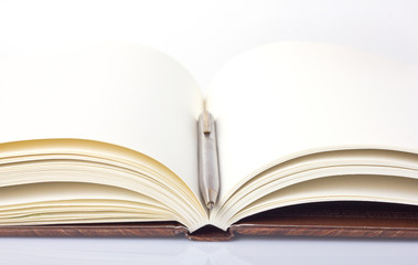 open book with blank pages and a pen