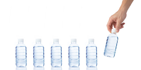 Male's hand grabs and holds a bottle of water with another bottl