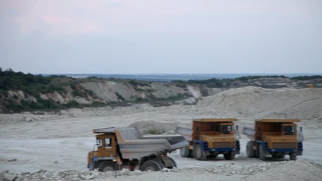 excavator loads a truck rock in the quarry
