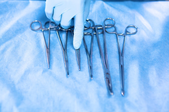 Detail shot of steralized surgery instruments with a hand grabbing a tool