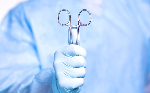 Detail shot of steralized surgery instruments with a hand grabbing a tool