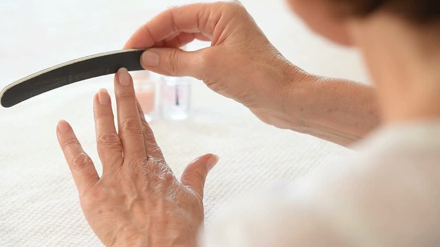 Woman filing her fingernails