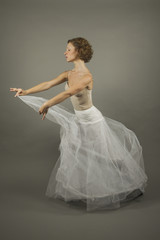 Fototapeta na wymiar Young expressive ballerina with a white long tutu practicing bal