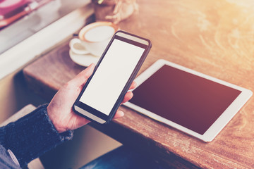 Close up hand woman using phone in coffee shop with vintage tone