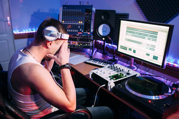 Tired DJ after hard work in sound recording studio. Exhausted DJ after overtime, he has problems...