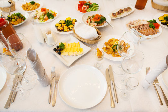 Table Served With Different Food And Flatware For Dinner. Beautiful Table Waiting For Guests. Wedding Reception Or Family Event Diner.

