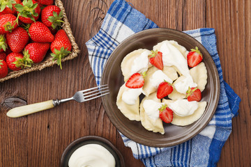 Delicious dumplings with fresh strawberries served with whipped