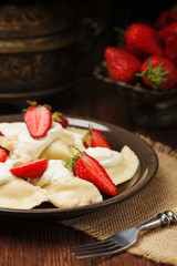 Delicious dumplings with fresh strawberries served with whipped