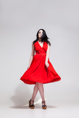 Black-haired woman twisting in red dress