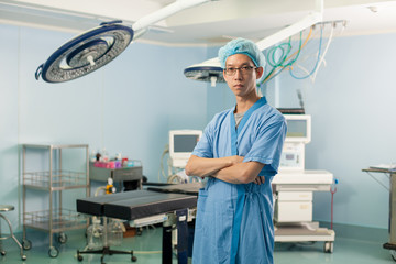 operation doctor, a male surgeon doctor crossing his arm in the operation room with equipment
