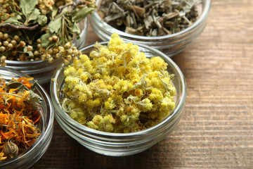 dried flowers dried herbs in glass bowl on wooden brown background