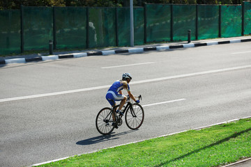 Female cyclist rides a racing bike on road