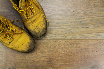 Muddy work boots on a wooden floor - 112710699