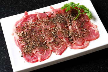 Premium raw japanese kobe beef sliced on plate with black pepper