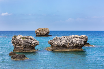 Fototapeta na wymiar Three separate rocks offshore in sea