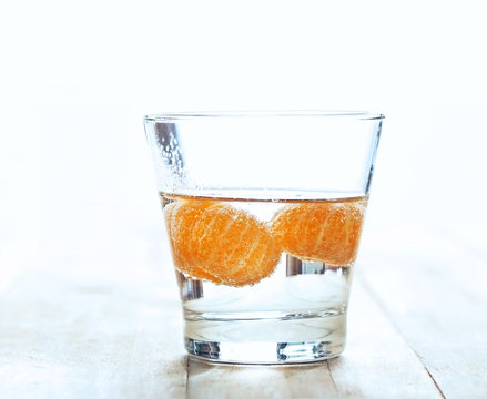 infusioned water of oranges in the glass on wooden background
